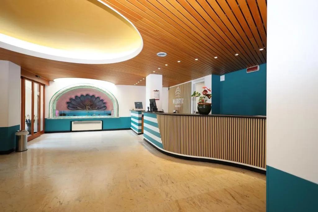 Hall dell'hotel con reception a righe turchesi, soffitto in legno e decorazione a conchiglia